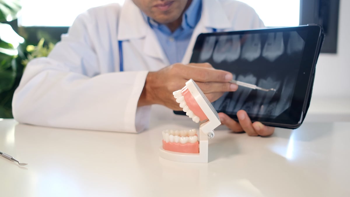 Cosmetic dentist explaining teeth whitening near me treatment options to a patient